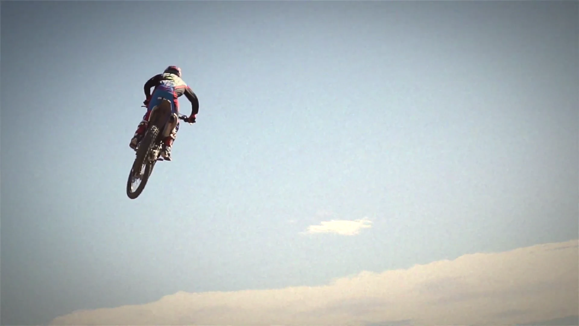 The real Racetrack SX film: a rider airborne against the sky